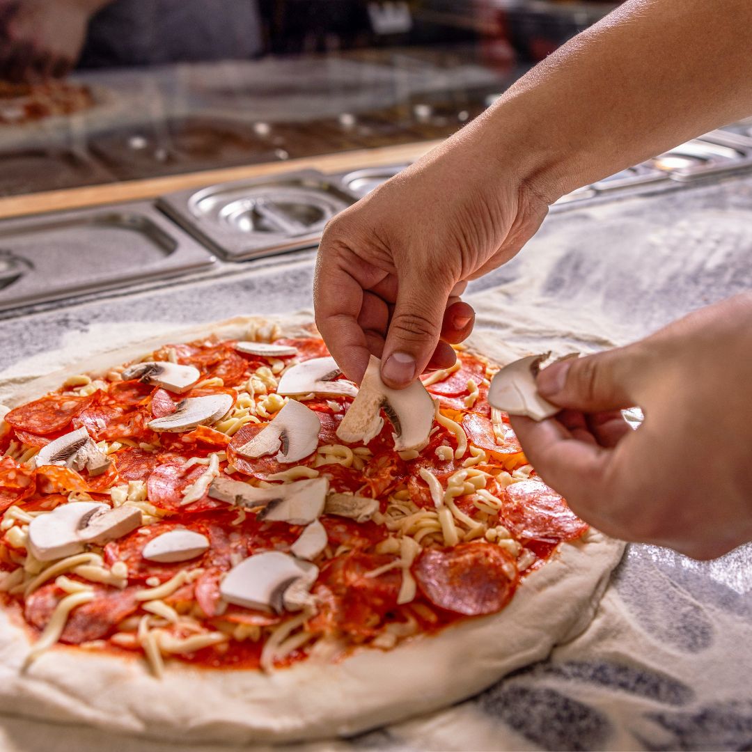 champignon op pizza leggen